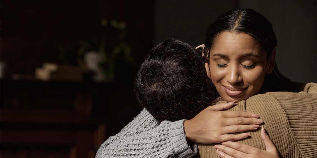 Adult female giving a loving hug to a child