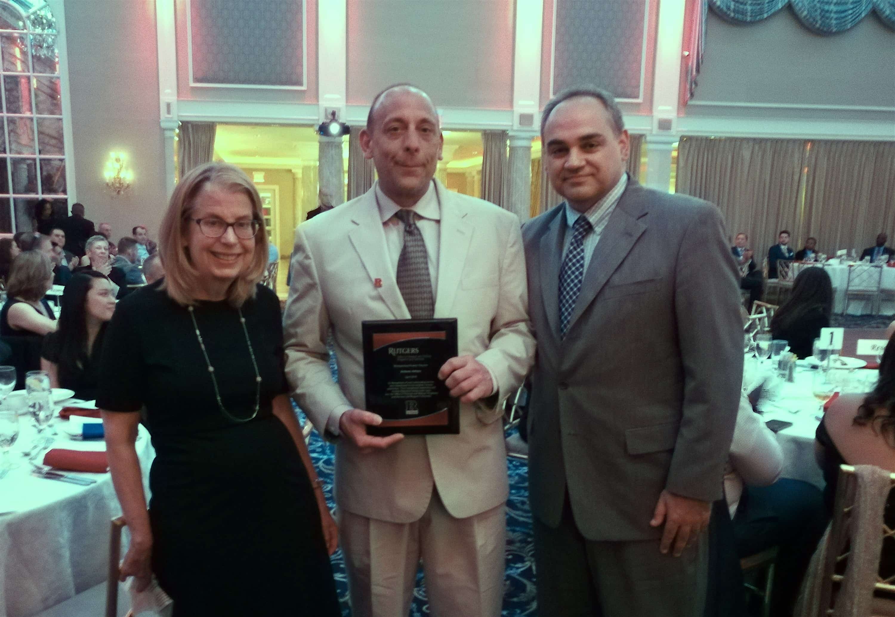 Nora Barrett, vice chair, and Douglas Lomonaco, assistant dean of student affairs, present Anthony Julliano with veterans award