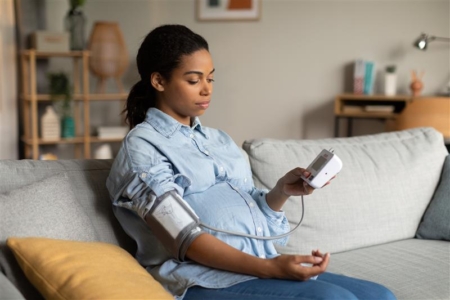 Pregnant woman taking her blood pressure