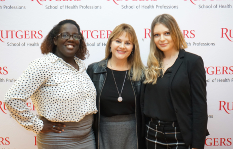 Two female scholarship winners pose with professor