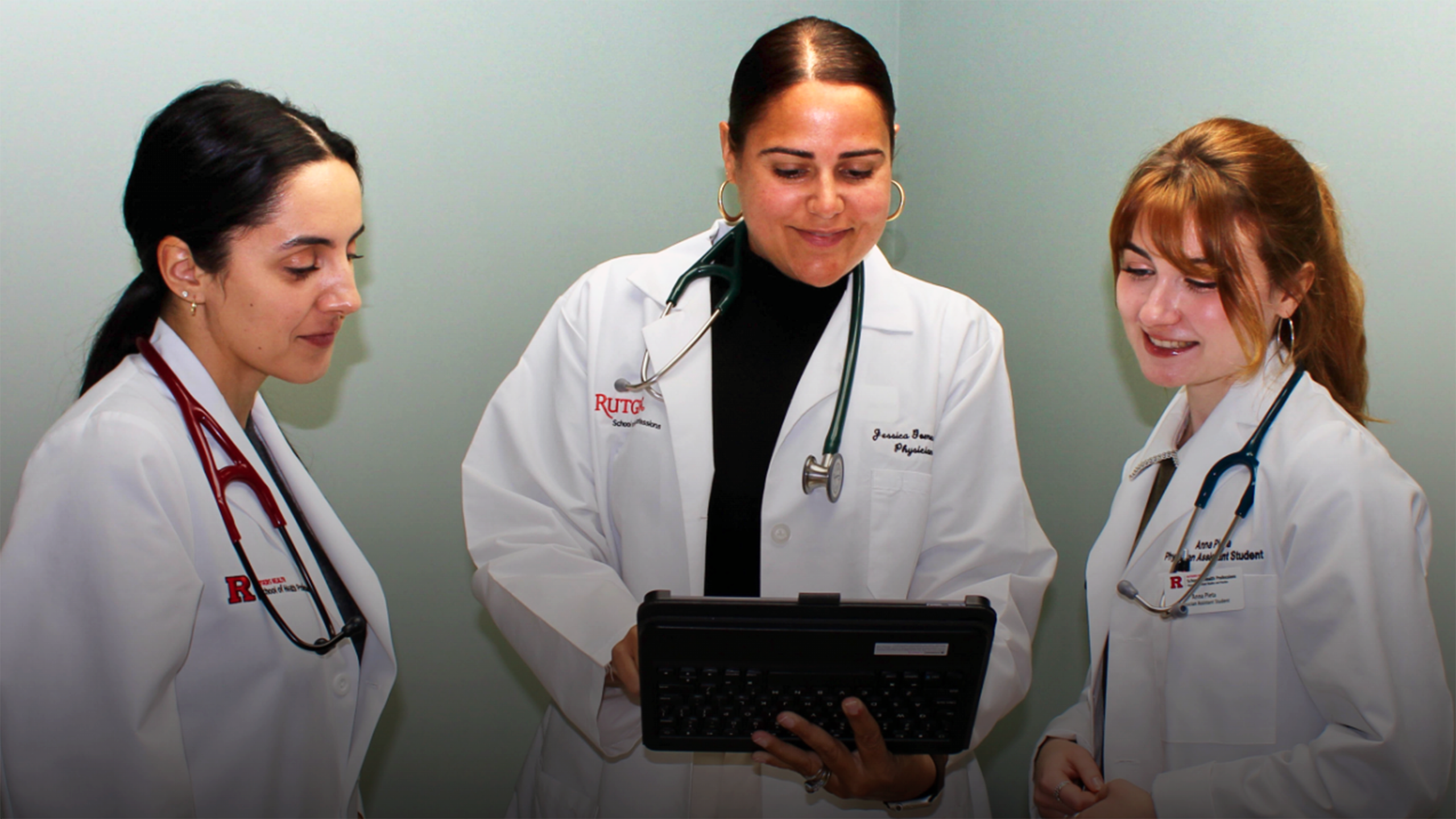 Anna Pieta and Alexandra Lawrence, students in the physician assistant program at Rutgers School of Health Professions, work with Jessica Gomes (center), an assistant professor and interpreter coordinator of the H.O.P.E. Clinic.