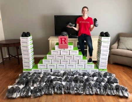 Molly Debutts with piles of donted shoes for health care workers